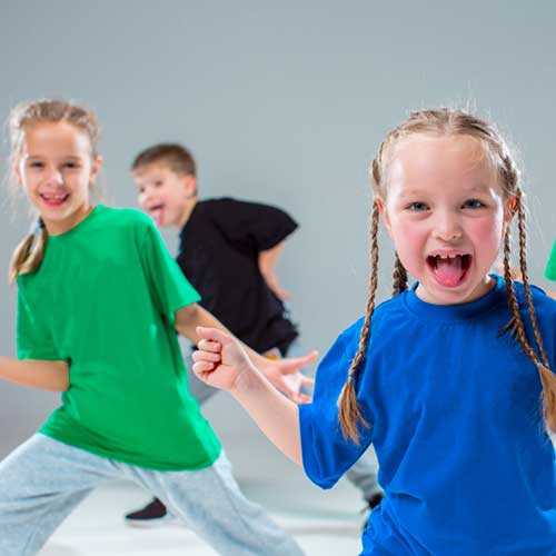Na zdjęciu: troje dzieci w tańcu.