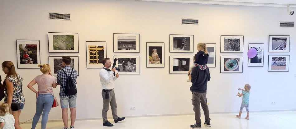 Widok Galerii w SDK podczas wernisażu wystawy ZEN, na ścianach prezentowane są fotografie wokół zwiedzający ludzie. 