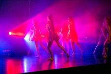 Na zdjęciu widoczna jest w dalszym ciągu ta sama grupa tancerek na scenie. Kolory światła w dalszym ciągu niebiesko-czerwone. 