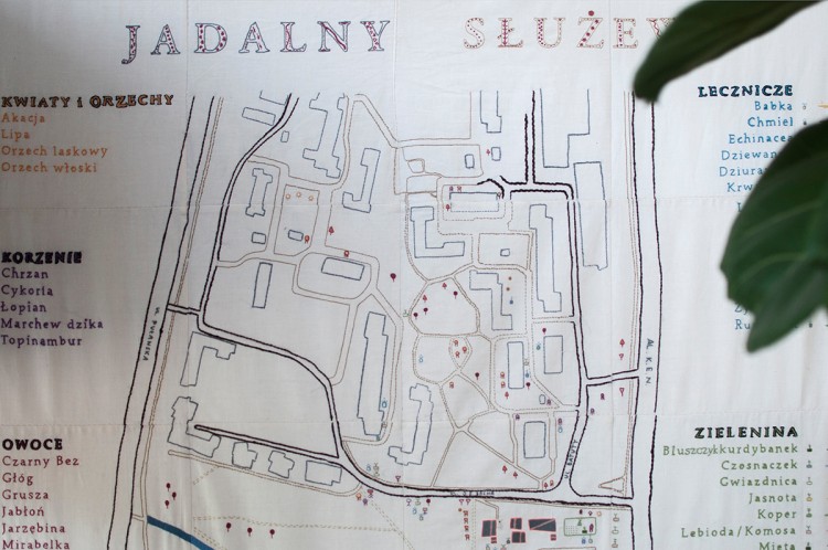 Na zdjęciu widoczna mapa roślin jadalnych okolic Służewa, wyhaftowana na białym materiale. 