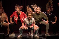Spektakl "Hejt Made" / Na zdjęciu widoczna jest grupa dziewcząt na scenie w ruchu. 