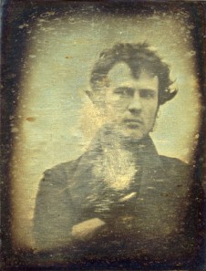Zdjęcie przedstawia pierwszy auoportret Roberta Corneliusa z 1839 roku. W kolorach sepii i w umiarkowanej ostrości widać mężczyznę w średnim wieku, z narzuconą lewą dłonią na prawej części szyi. Ubrany w ciemne kolory, włosy krótkie, potargane. W tle jednolity kolor.