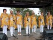 Występ na Południowo Praskich Senioraliach. Na scenie 7 wokalistek zespołu Służewianki przy mikrofonach na statywach. Ubrane w żółte bluzki oraz białe spodnie. 