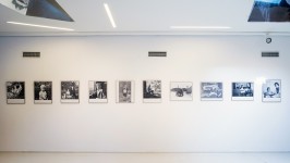 Panoramiczne zdjęcie ukazujące fragment wystawy czarno białych fotografii - scen z życia Zdzisława Beksińskiego.