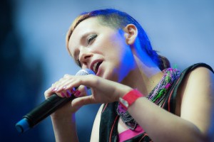 Na zdjęciu wokalistka trzymająca mikrofon w ręku. Bliskie zbliżenie. Wokalistka ma krótko scięte włosy. fot Bartłomiej Muracki