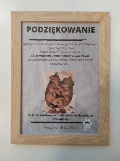 Podziękowania od OTOZ Animals dla SDK za przekazanie darów na rzecz zwierząt. Dyplom jest włożony w drewianą ramkę. Tło białe.
